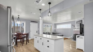 A modern kitchen with a central island, wooden dining table, and chairs. - Merry Melly, The Midtown Charmer! Close to Midtown, downtown, freeway, airport (Reno)