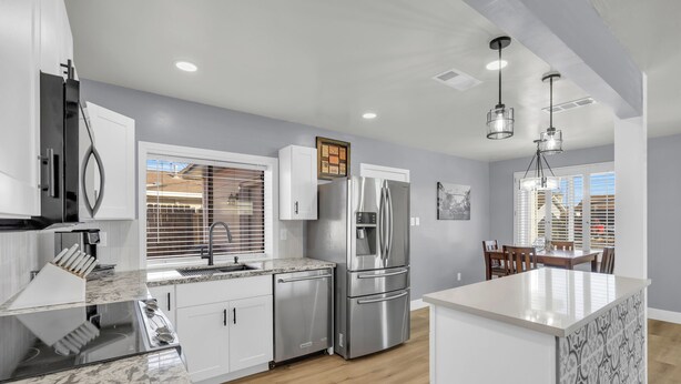 A modern kitchen with stainless steel appliances, white cabinetry, and a marble countertop. - Merry Melly, The Midtown Charmer! Close to Midtown, downtown, freeway, airport (Reno)