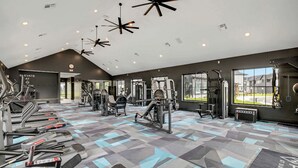 Ett modernt gym med löpband, styrketräningsmaskiner och ett mönstrat golv.