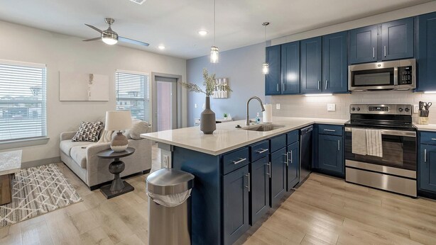 A modern kitchen with dark blue cabinets, stainless steel appliances, and a central island. - Landing | Beautiful 1BD in Grand Prairie (Grand Prairie)