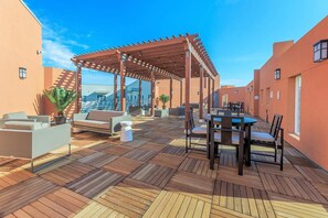 A rooftop terrace with a pergola, outdoor seating, and a view of the cityscape. - Landing | Incredible 1BD in Grand Prairie (Grand Prairie)