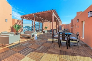 A rooftop terrace with a pergola, outdoor seating, and a view of the cityscape. - Landing | Chic 2BD in Grand Prairie (Grand Prairie)