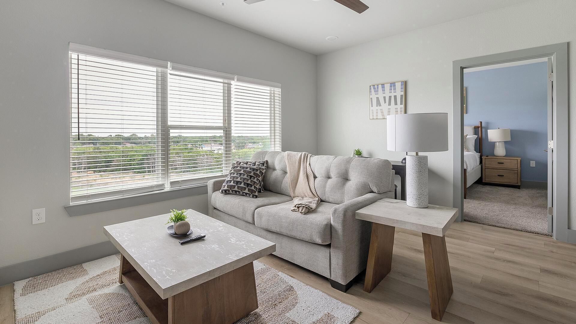 A modern living room with a sofa, coffee table, and a lamp.