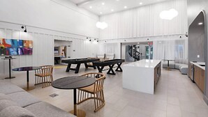 A spacious, modern kitchen with a central island, dining area with chairs, and a pool table. - Landing | Incredible 2BD, Gym, Game Room (Bellview)
