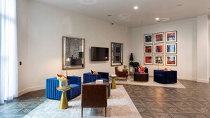 Un salon spacieux comprenant un grand canapé, une table basse et un téléviseur fixé au mur.