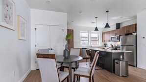 Een moderne keuken met houten kasten, roestvrijstalen apparatuur en een centraal eiland.