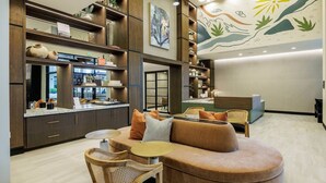 A modern interior with a sofa, chairs, a bar area, and a reception desk. - Landing | Modern 1BD, Gym (Austin)