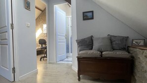 Ein Loft-Zimmer mit einer Holzbank, einer Steinwand und einer Tür zu einem anderen Raum.