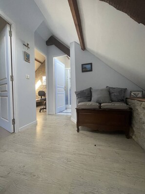 Ein Loft-Zimmer mit einer Holzbank, einer Steinwand und einer Tür zu einem anderen Raum.
