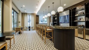 A modern hotel room with a dining area, a bar, and a large window with curtains. - Landing | Spectacular 1BD, Gym (Austin)