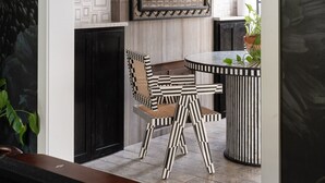 Une pièce moderne comprenant une table à manger, des chaises et une œuvre d’art encadrée accrochée au mur.