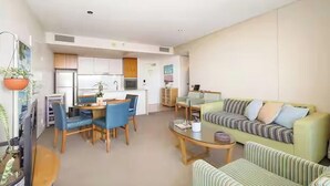 Een moderne woonkamer met een bank, een salontafel en een eethoek met stoelen en een tafel.
