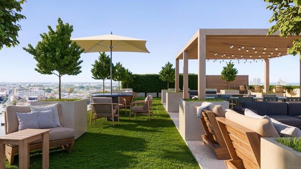 Een dakterras met tuinmeubilair, een pergola met lichtslingers en uitzicht op de stad.