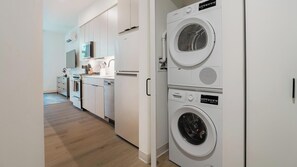 A modern kitchen with white cabinetry, a built-in oven, and a microwave. - Landing | Spectacular Studio in Lincoln Park (Chicago)