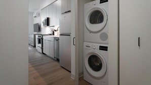 Une cuisine moderne équipée d’appareils électroménagers intégrés, d’un four à micro-ondes et d’un lave-linge Bosch.