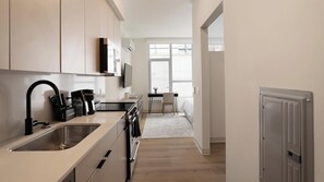 A modern kitchen with a built-in oven, a coffee machine, and a sink. - Landing | Beautiful Studio in Lincoln Park (Chicago)
