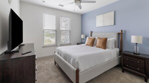 A bedroom with a bed, two bedside tables, a TV, and a ceiling fan. - Landing | Incredible 1BD in Downtown Fort Worth (Fort Worth)