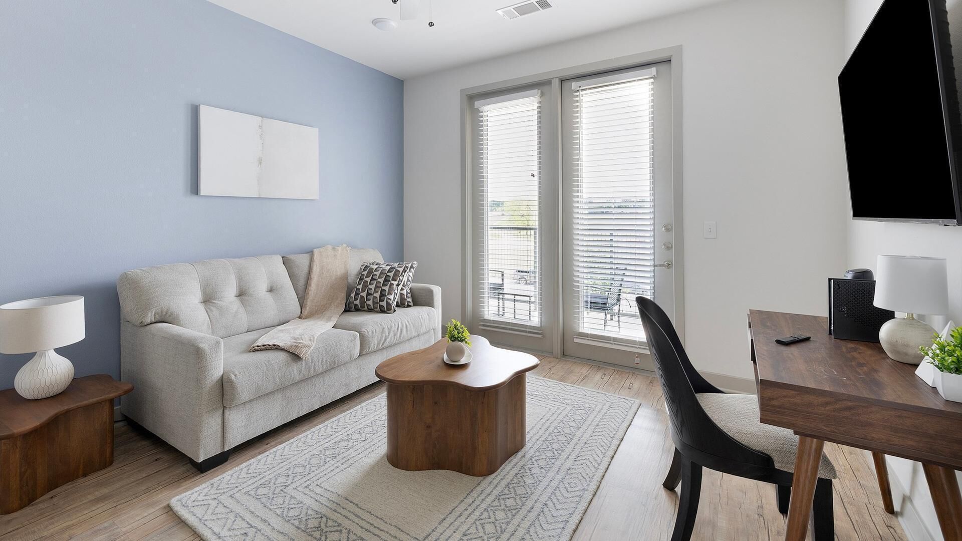A modern living room with a sofa, coffee table, and dining area.