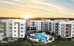 A modern apartment complex with a central swimming pool surrounded by lounge areas and outdoor seating. - Landing | Modern 1BD in Downtown Fort Worth (Fort Worth)