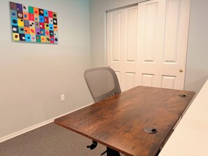 A conference room with a wooden table, a single office chair, and a door in the background. - Wonderful 2-bedroom entire guest suite with AC in charming Sammamish (Sammamish)