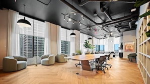 Una sala de conferencias moderna con una gran mesa, asientos cómodos y ventanas amplias con vista a la ciudad.