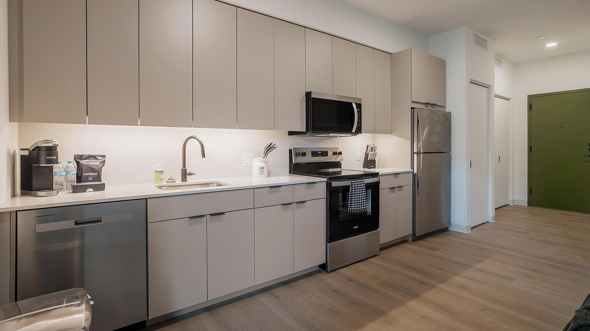 A modern kitchen with stainless steel appliances, a microwave, and a refrigerator.