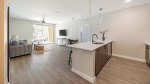 A modern apartment with a kitchen, dining area, and living room. - Landing | Modern 2BD, Clubhouse, Pool (Goodyear)