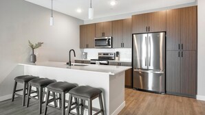 Una cocina moderna con una isla central, electrodomésticos de acero inoxidable y armarios de madera.