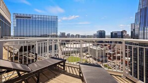 Ein Balkon mit Blick auf eine Stadtansicht, darunter ein Bridgestone-Gebäude.