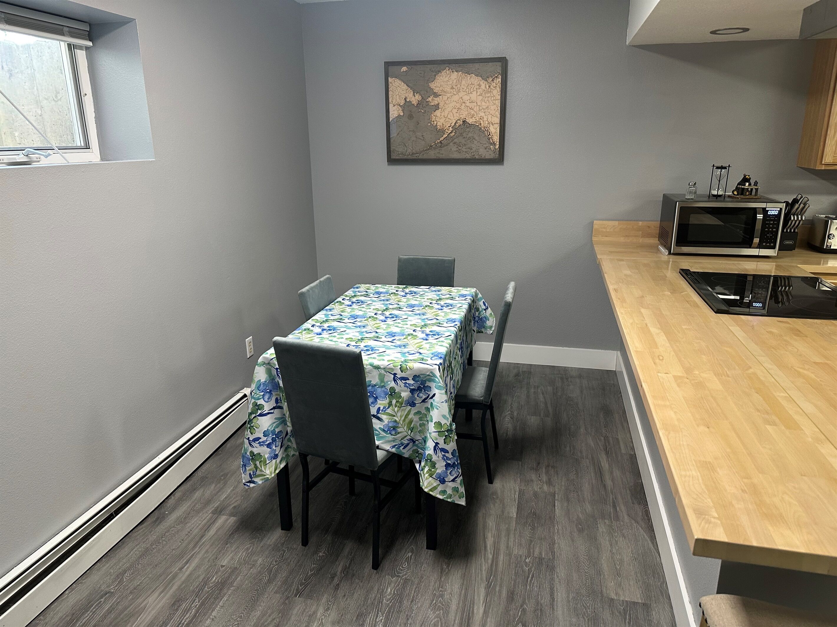 A dining area with a table and chairs, a microwave, and a map on the wall.