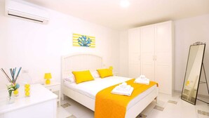 A hotel room with a bed, bedside table, lamp, air conditioning unit, wardrobe, and a mirror. - Casa Floriana Seaview - Panoramic Terrace in Capri (Capri)