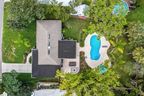 An aerial view of a house with a swimming pool, a covered patio, and a well-maintained lawn. - Island Retreat Located between Downtown and the Beaches (St. Augustine)