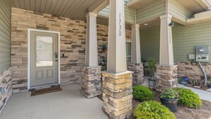A house with a stone facade, a front door, and a welcome mat. - Fall Savings - House w/ Pool, indoor games & only 5 miles to Navarre Beach (Navarre)