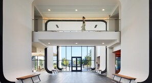 Ein modernes Gebäude mit Glasfassade, einer Treppe und einer Person, die darauf geht.