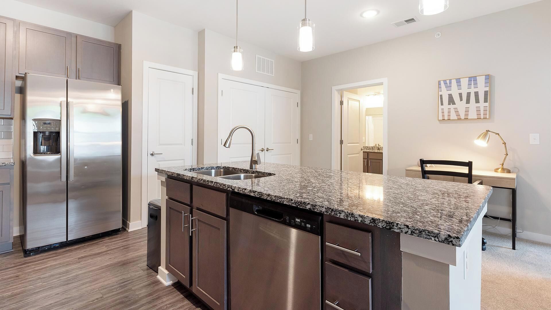 A modern kitchen with stainless steel appliances, granite countertops, and a central island.