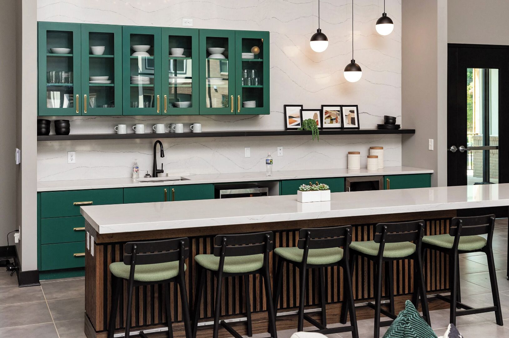 Une cuisine moderne avec des meubles de couleur verte, un plan de travail blanc et des tabourets de bar.