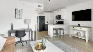 Een modern appartement met een keuken, eethoek en woonkamer.