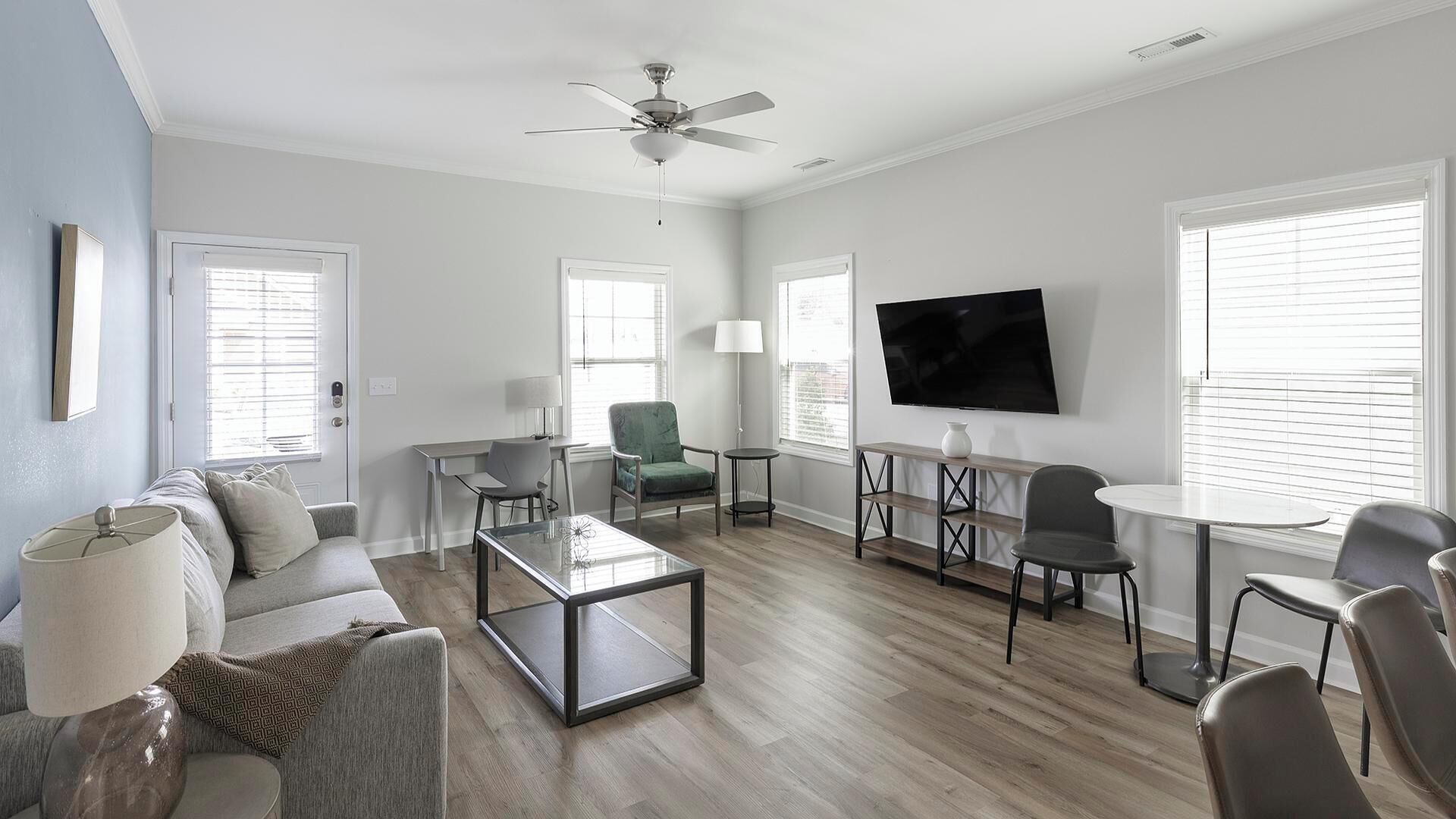 A modern living room with a sofa, coffee table, TV, and seating area.