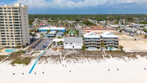 Un hôtel situé sur la côte, avec plusieurs étages, une piscine et un accès direct à la plage.