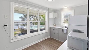 A modern kitchen with a large window, a built-in oven, and a view of a hot tub.