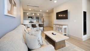 A modern living room with a sofa, coffee table, and TV. - Landing | Spectacular 1BD, Clubhouse, Game Room (Mansfield)