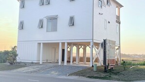 Un bâtiment blanc doté d’un porche et d’une enseigne.