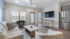 Uma sala de estar moderna com sofá, mesa de centro e televisão.