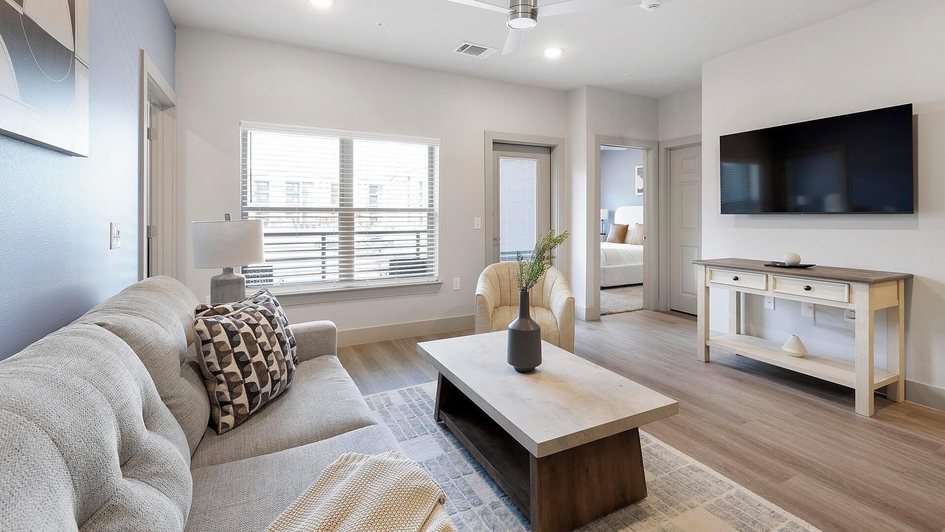 A modern living room with a sofa, coffee table, and TV.