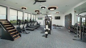 A gym with treadmills, a stair climber, and weight machines. - Landing | Spectacular 1BD, Gym (Houston)