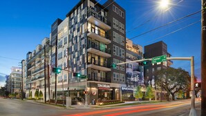 A multi-story building with commercial spaces on the ground floor, including a restaurant and a dental office. - Landing | Spectacular 1BD, Gym (Houston)