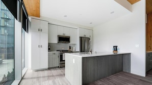 Una cocina moderna con armarios blancos, electrodomésticos de acero inoxidable y una isla grande.