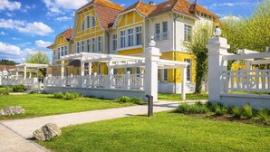A large, yellow and white building with a red-tiled roof, surrounded by a white fence and a well-maintained lawn. - The Happy House - Welkeys (Saint-Georges-d'Oléron)