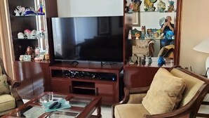 Olohuone, jossa on televisio, puuhuonekaluja ja koriste-esineitä.