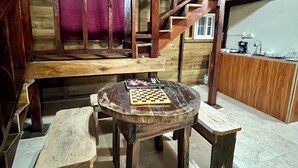 Ein rustikales Holzinnere mit einem runden Holztisch, Bänken und einer Treppe.